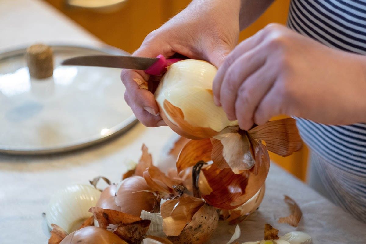 женщина чистит лук