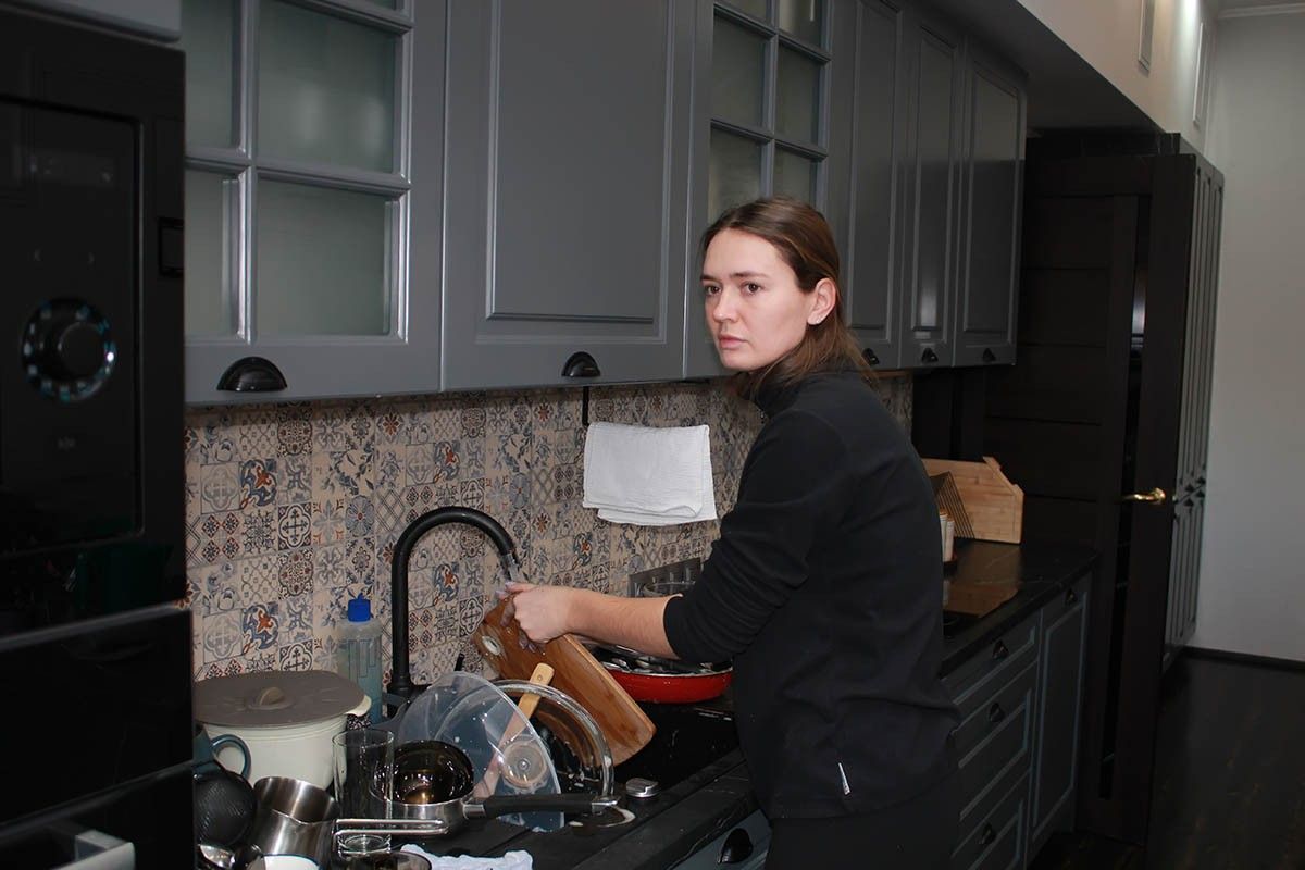 женщина моет посуду на кухне